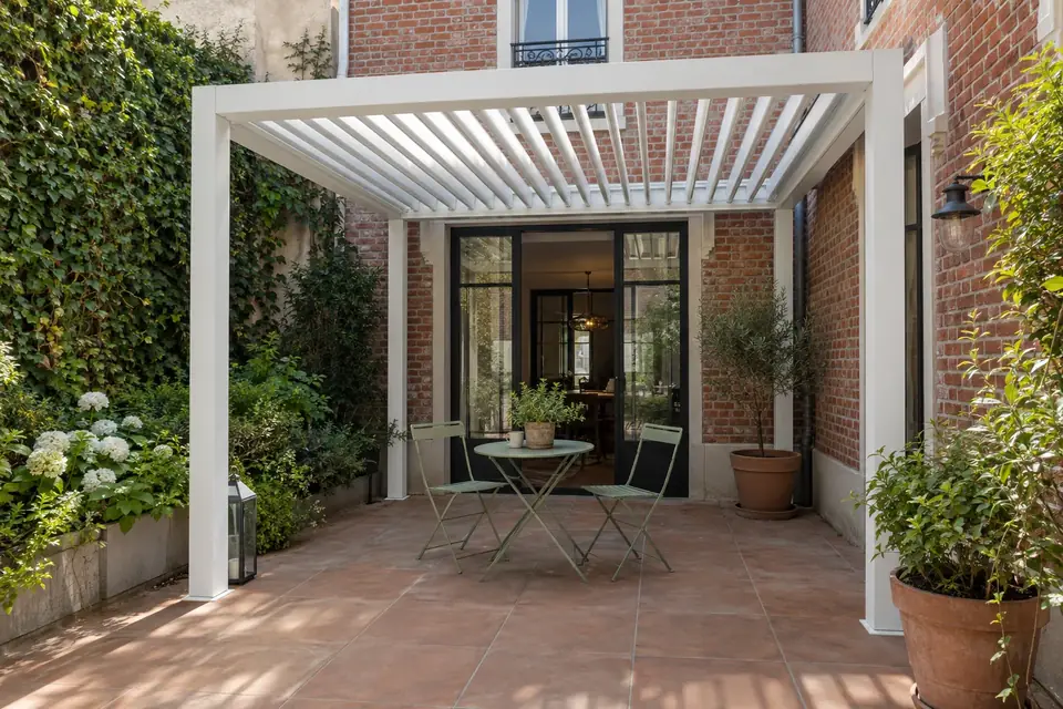 Pergola bioclimatique compacte sur une terrasse ombragée de jardin méditerranéen